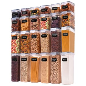 Clear storage containers labeled with various food items such as cookies, pretzels, chips, pasta, oatmeal, rice, and more, neatly stacked in four rows.