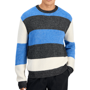 A striped sweater featuring wide bands of blue, black, and white with a ribbed texture, worn with black pants.