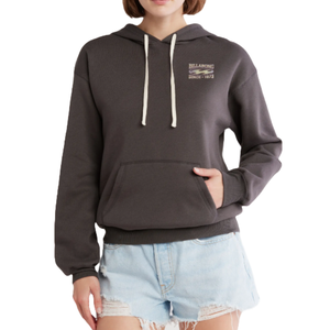 A person wearing a dark gray Billabong hoodie with a small logo on the chest and light blue distressed denim shorts.