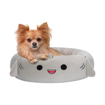 A small dog is sitting in a gray, plush pet bed designed to resemble a smiling cartoon character.