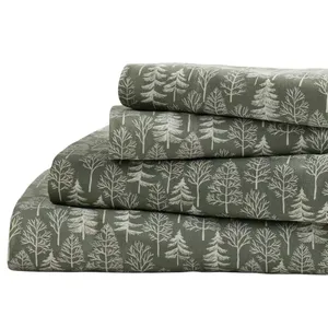 A stack of bedsheets with a forest tree pattern in white on a dark green background.
