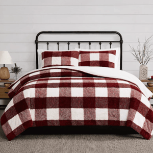 Red and white checkered bedding set on a bed with a black metal frame, accompanied by wooden bedside tables and simple decor.