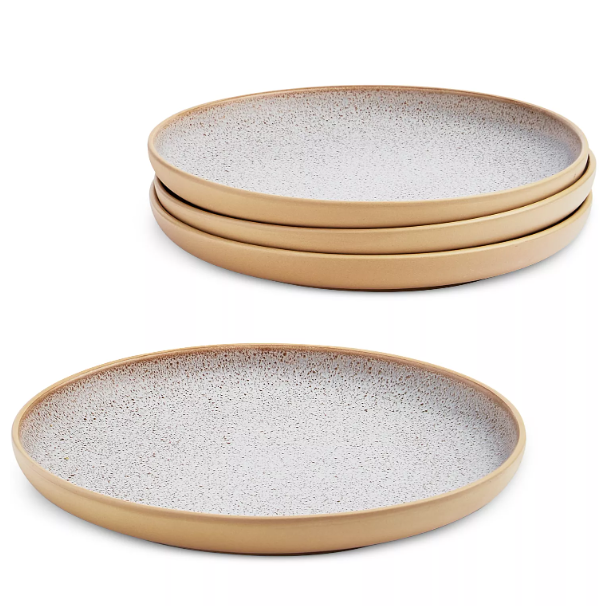 Set of round stoneware plates with a speckled white interior and smooth tan exterior, designed for stylish dining.