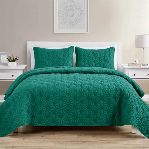 Teal King Quilt Set includes a quilt and two pillow shams, featuring a textured geometric pattern. The set is displayed in a minimalist bedroom with a white bed frame and side tables.