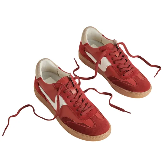 A pair of red sneakers with white accents, featuring suede and leather uppers, and gum-colored soles.