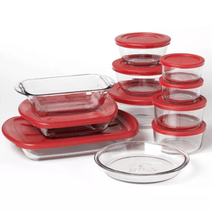 A set of clear glass storage containers with red lids in various shapes and sizes, including rectangular, circular, and oval dishes.