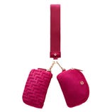 Magenta crossbody bag with two zippered pouches, one featuring a textured pattern. The strap connects to the pouches with gold hardware.