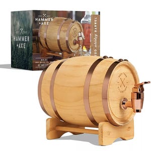 A 1L mini whiskey barrel made of wood with copper accents, featuring a tap for dispensing and a sturdy stand. The packaging displays the same barrel, labeled \“Hammer + Axe,\“ with a focus on personalized whiskey aging.