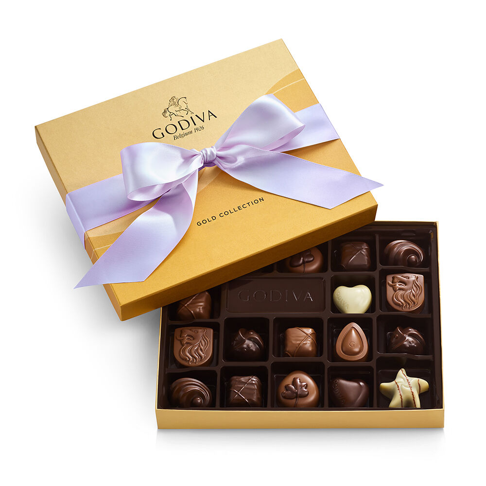 Godiva Gold Collection box featuring assorted chocolates with various shapes, including hearts and stars, tied with a light purple ribbon.