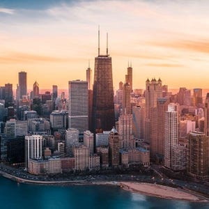Aerial view of Chicago skyline at sunset with the John Hancock Center prominently featured.