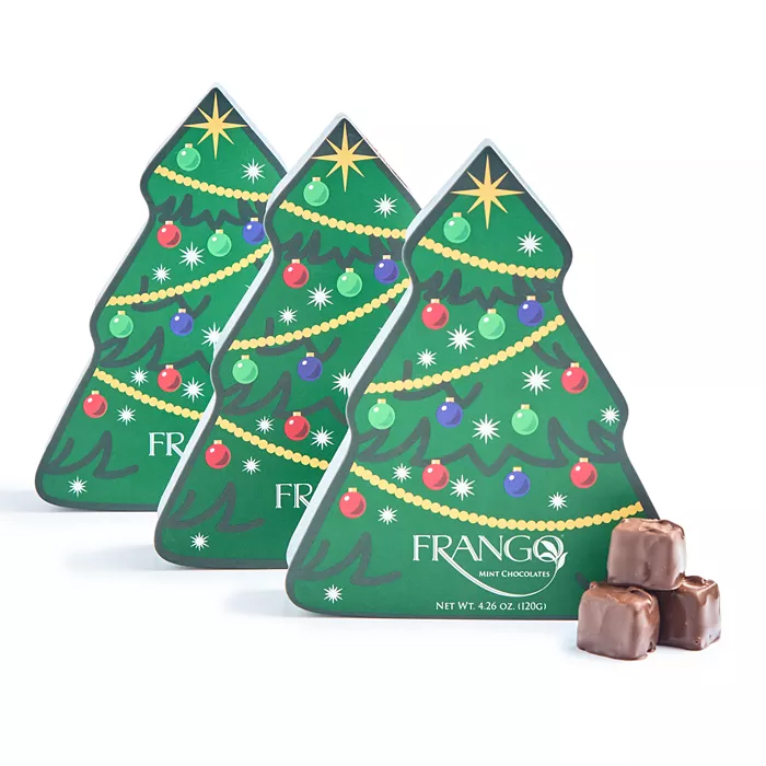 Three tree-shaped boxes of Frango Mint Chocolates, decorated with Christmas ornaments and stars, each weighing 4.26 oz (120g). Two stacked chocolate pieces are shown beside the boxes.