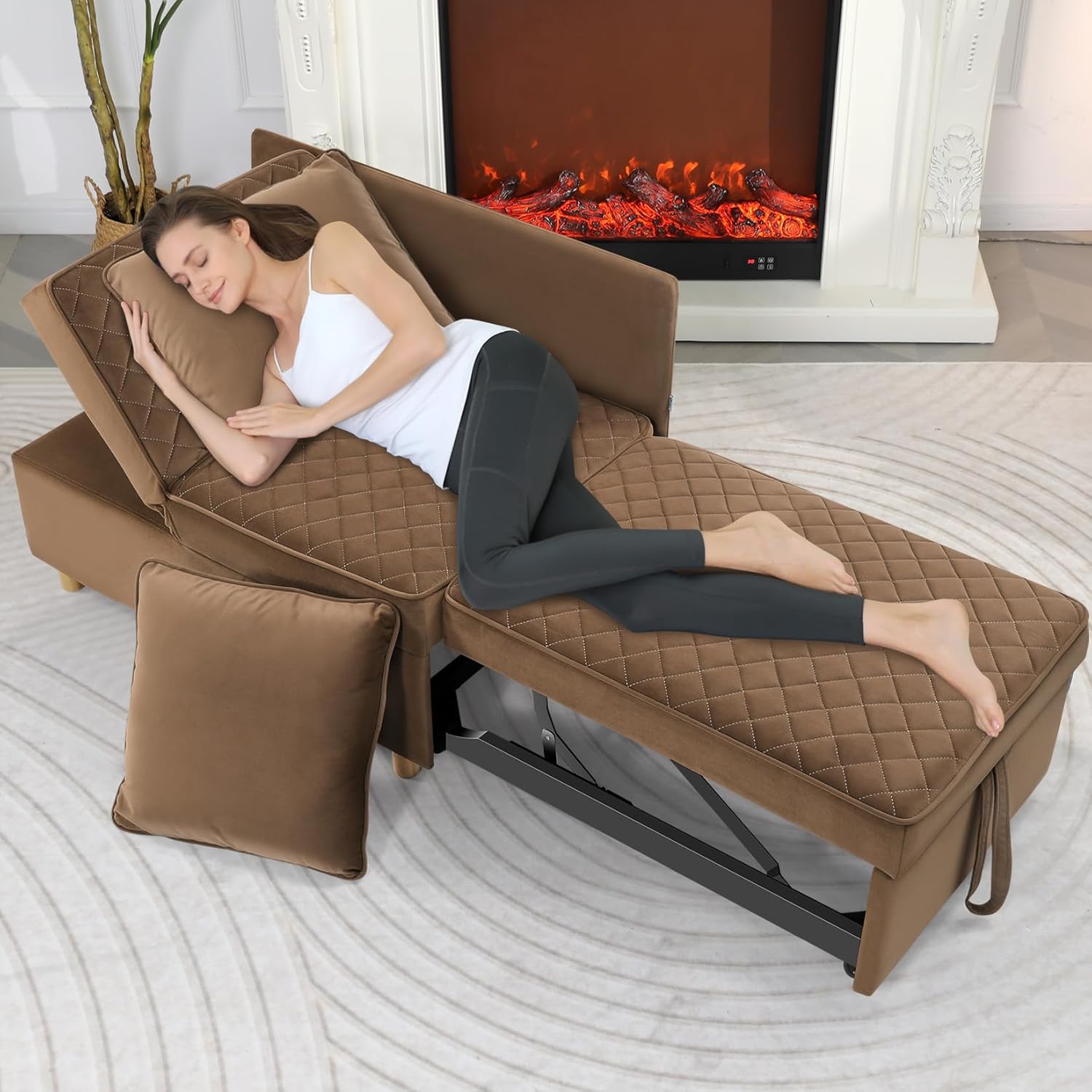 A brown convertible futon bed with a quilted surface transforms into a chaise lounge or flatbed. It features supportive legs and an adjustable backrest, complemented by matching pillows, placed in front of an electric fireplace.