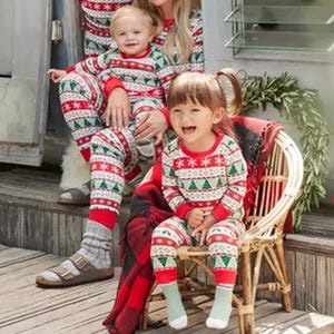 Matching holiday-themed pajamas worn by a family, featuring red, white, and green patterns.