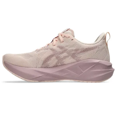A light pink athletic shoe with a cushioned sole and minimalistic design, featuring a subtle pattern on the side and lace-up closure.
