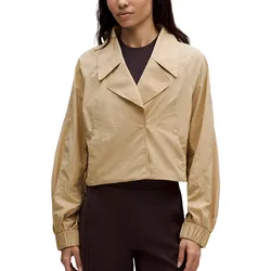 A beige cropped jacket with a wide collar, long sleeves, and elastic cuffs, paired with dark, high-waisted pants.