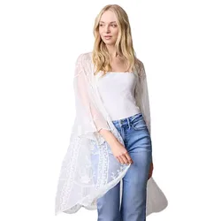 A woman is wearing a white, sheer lace kimono over a white top, paired with blue jeans.