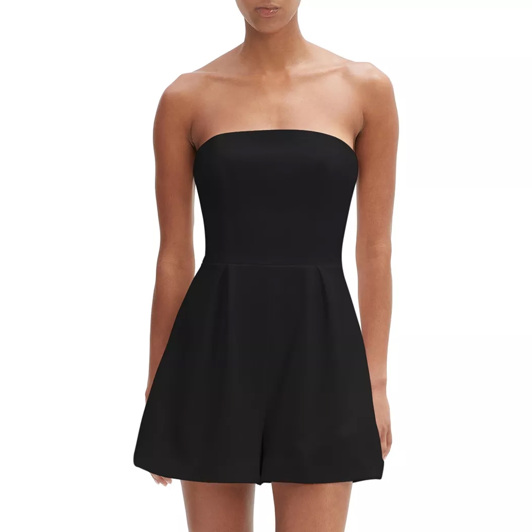 Strapless black romper with a fitted bodice and pleated shorts, suitable for casual or semi-formal occasions.