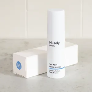 Musely FaceRx Anti-Aging Cream, targeting wrinkles, texture, pores, and acne, in a white cylindrical bottle with a blue stripe at the bottom, accompanied by a white box with a blue M logo.
