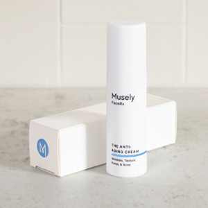 Musely FaceRx Anti-Aging Cream, targeting wrinkles, texture, pores, and acne, in a white cylindrical bottle with a blue stripe at the bottom, accompanied by a white box with a blue M logo.