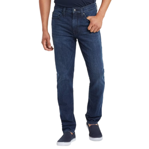 A person is wearing dark blue jeans with a straight fit, paired with dark slip-on shoes.