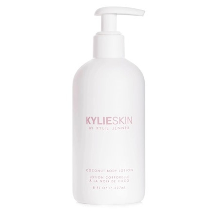 A white bottle with a pump top labeled \“KYLIESKIN by Kylie Jenner, Coconut Body Lotion.\“ The text is in a simple, modern font.
