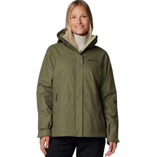 A woman is wearing a green Columbia hooded jacket, which features a front zipper and two zippered pockets.