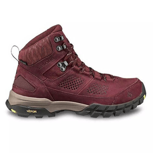 A maroon hiking boot with a high ankle design, featuring a Vibram sole for enhanced traction and metal eyelets for sturdy lacing.