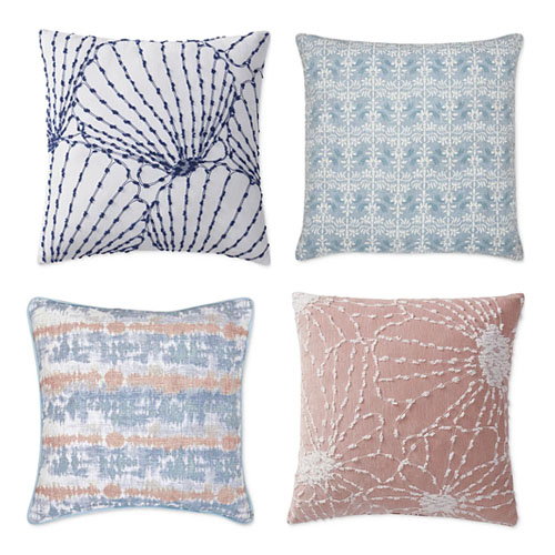 Four decorative pillows with varying designs: striped, snowflake, abstract, and floral patterns.