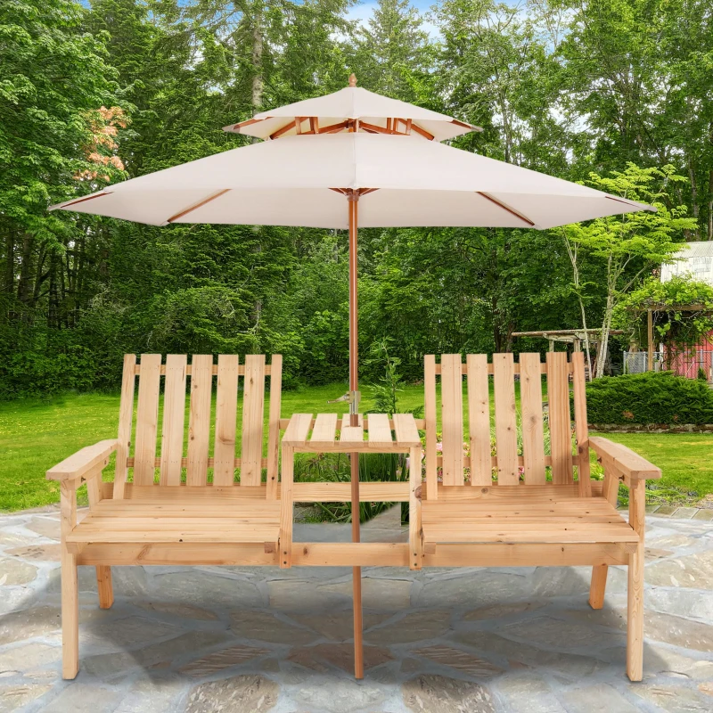 Wooden double garden bench with built-in table and a large white patio umbrella, set on a stone patio amidst a lush green garden.