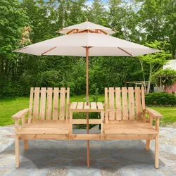 Wooden double garden bench with built-in table and a large white patio umbrella, set on a stone patio amidst a lush green garden.
