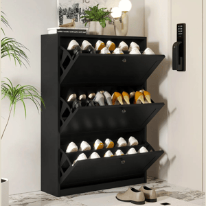 Black shoe storage cabinet with three drop-down compartments, holding multiple pairs of shoes. Decor includes plants and a lamp on top, with a nearby electronic door lock.