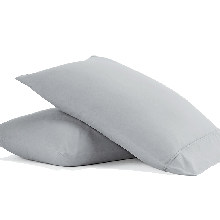 Two light gray pillows with a simple, smooth texture, stacked on top of each other.