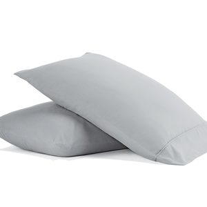 Two light gray pillows with a simple, smooth texture, stacked on top of each other.