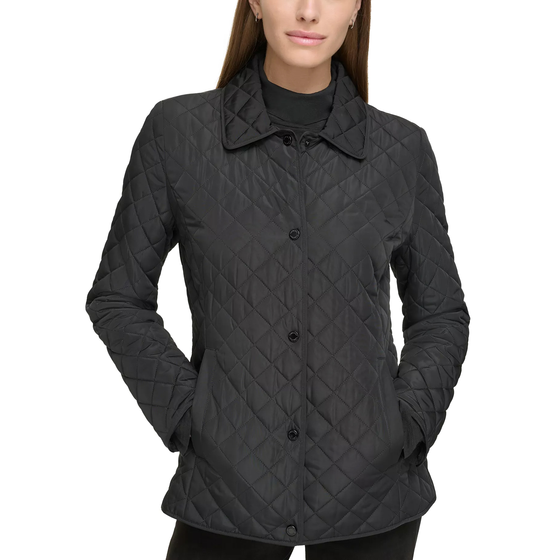 A woman wearing a black quilted jacket with a button-up front and collared design. The jacket has diagonal stitching and side pockets.