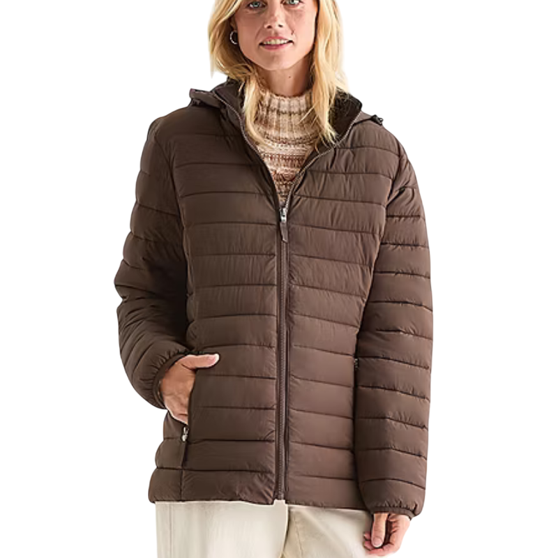 A woman is wearing a brown quilted jacket with a zipper and hood. She has one hand in the pocket and is dressed in a knit sweater and light-colored pants.