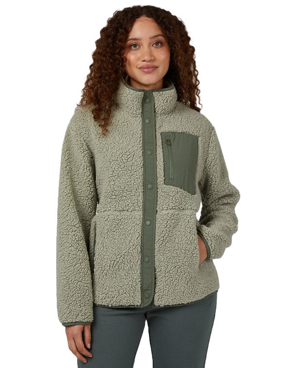 A woman wearing a textured olive-green sherpa jacket with a high collar and button-up front.