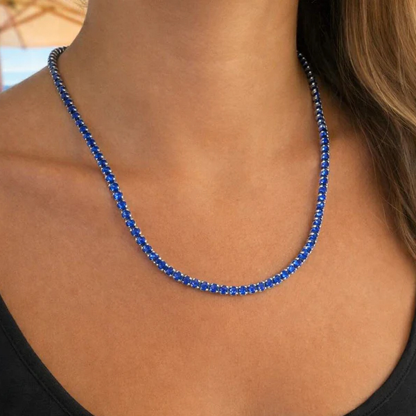 A person is wearing a sapphire blue beaded necklace, complemented by a black top.