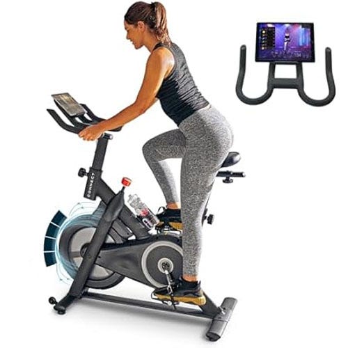 A person rides a stationary exercise bike equipped with a digital screen. Additionally, a close-up of the bike's handlebar and tablet holder setup is shown.