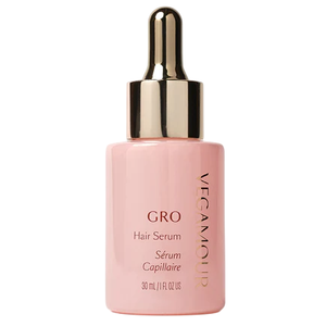 A pink bottle of Vegamour GRO Hair Serum with a gold dropper, labeled as 30 mL / 1 fl oz.