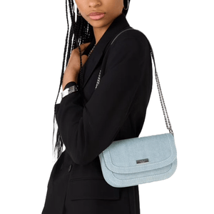 The Kate Spade Denim Chain Crossbody is a small, blue denim bag with a flap closure and a silver chain strap. It features a discreet logo plaque on the front.