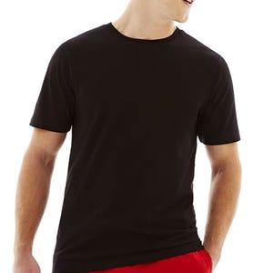 A person wearing a plain black T-shirt with short sleeves, paired with red shorts.
