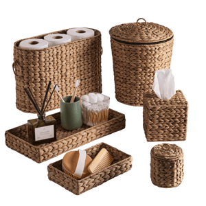 Set of woven baskets and trays, including a toilet paper holder, waste bin, tissue box, and small trays with personal care items like toothbrushes and a comb.