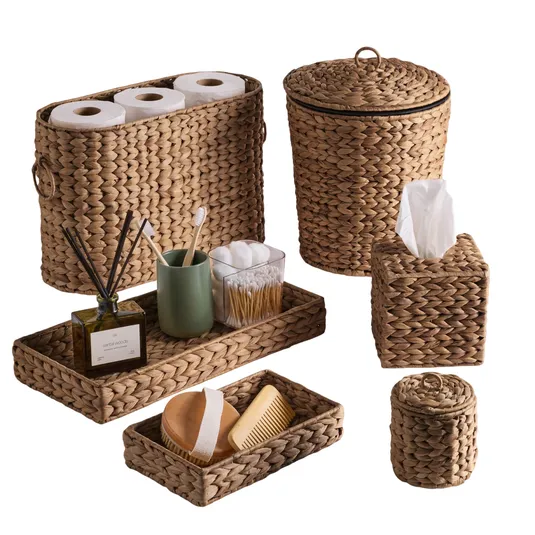 Set of woven baskets and trays, including a toilet paper holder, waste bin, tissue box, and small trays with personal care items like toothbrushes and a comb.