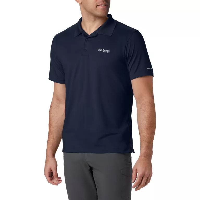 A man is wearing a dark blue Columbia performance polo shirt with a logo on the chest, paired with gray pants.