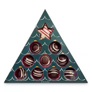 A triangular, Christmas tree-shaped box containing 9 hot cocoa bombs with decorative stripes and a star-shaped bomb at the top. Each bomb is designed to be submerged in hot milk to create cocoa.