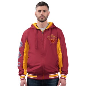 A man wears a maroon and yellow jacket with \“3X Super Bowl Champions\“ and a \“W\“ logo. The sleeves showcase multiple football championship patches.