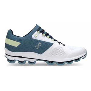 The On Cloudsurfer 6 Shoes are athletic sneakers featuring a breathable mesh upper in blue and white with black accents, a distinctive cushioned sole with cloud-like segments, and the \“On\“ logo on the side.