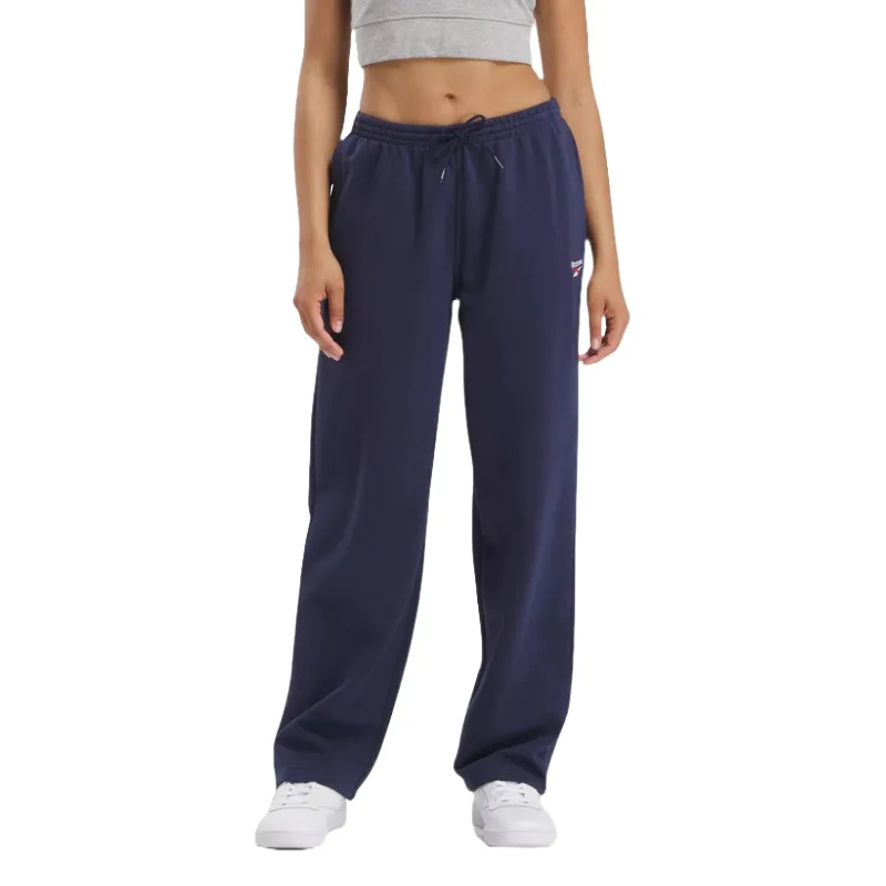 Navy blue sweatpants with a drawstring waist, featuring a small Reebok logo on the left side. They have a relaxed fit and are paired with white sneakers and a gray crop top.