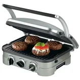 A countertop grill with adjustable settings is cooking four burger patties, one topped with cheese, tomato, and basil.