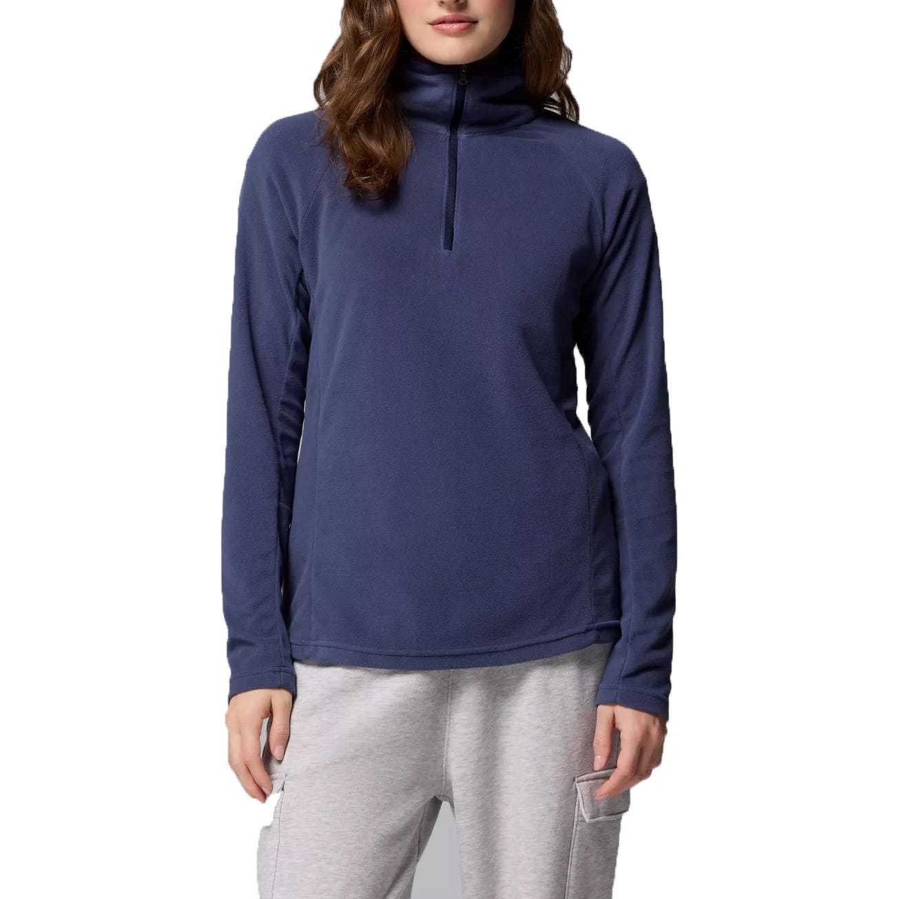 A woman is wearing a navy-blue long-sleeve fleece pullover with a half-zip collar, paired with light gray sweatpants.